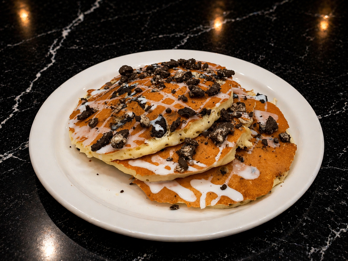 a plate of pancakes with chocolate chips and icing