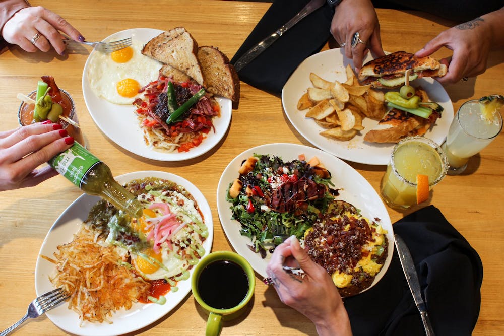 a group of people sitting at a table with a plate of food