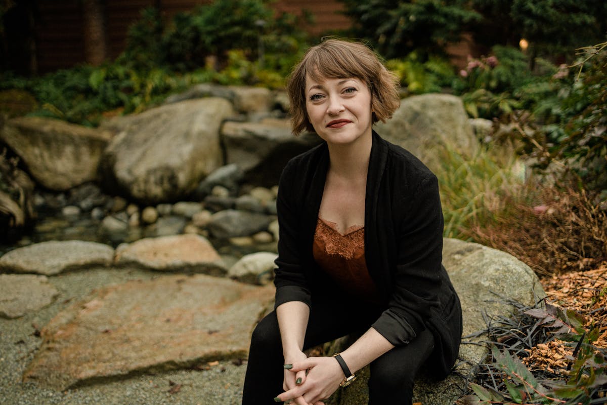 a woman sitting on a rock