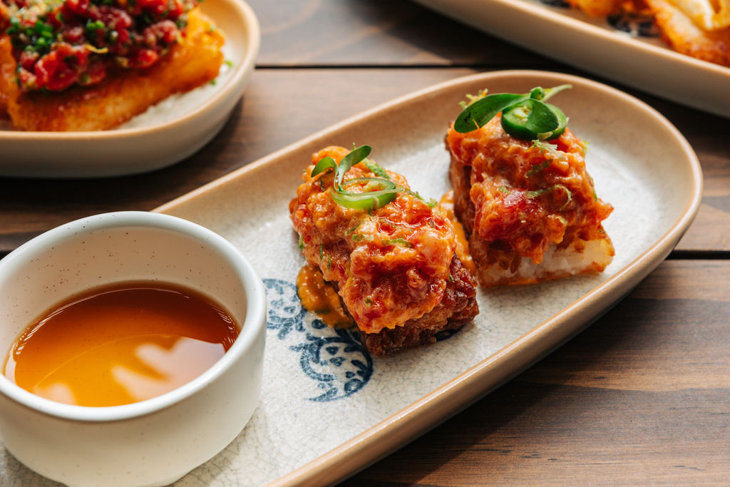 food on a plate with a cup of sauce