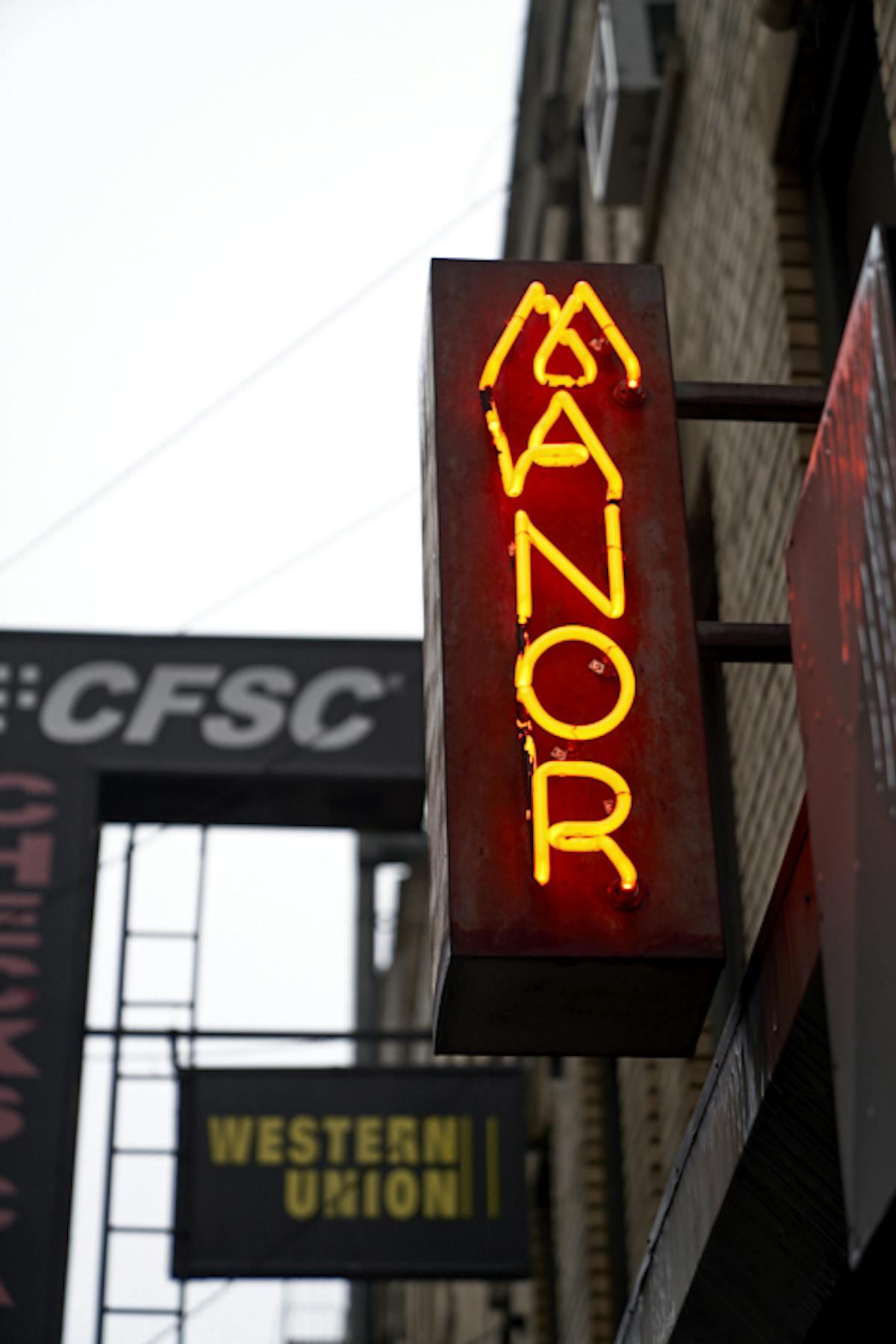 a sign hanging off the side of a building