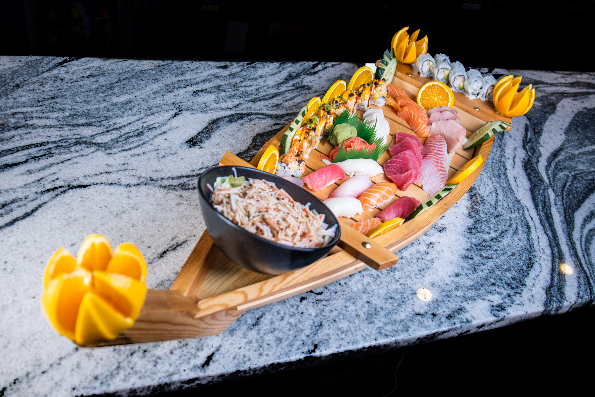 a bowl of fruit sitting on top of a cutting board with a cake