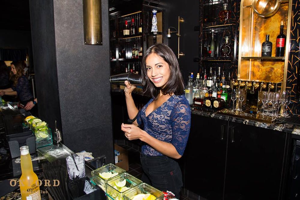 a person standing next to a bottle of wine on a table