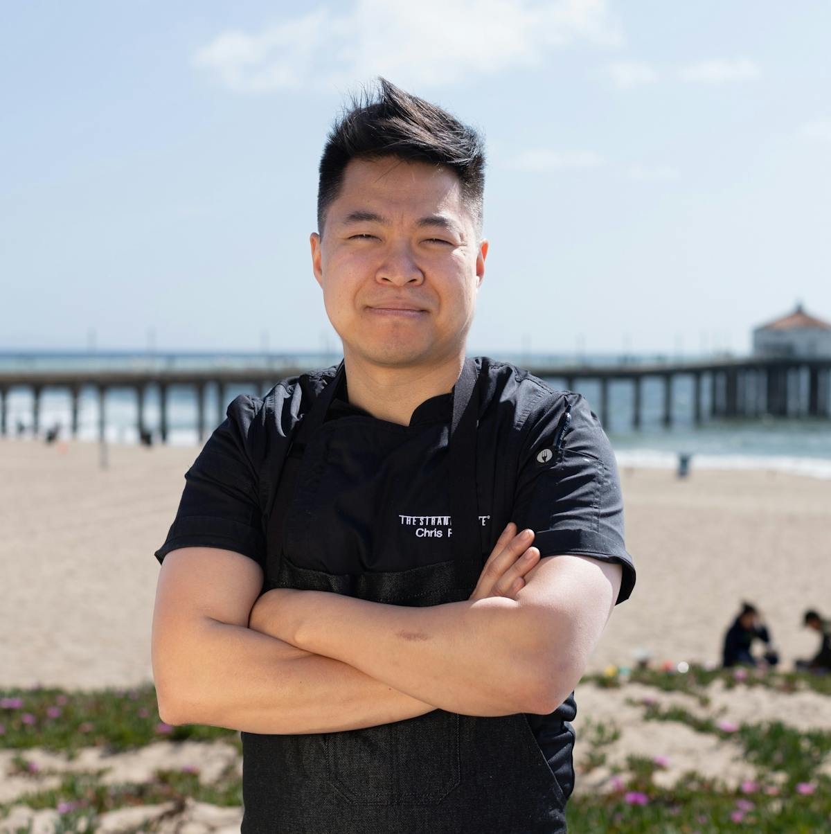 a man with crossed arms on a beach