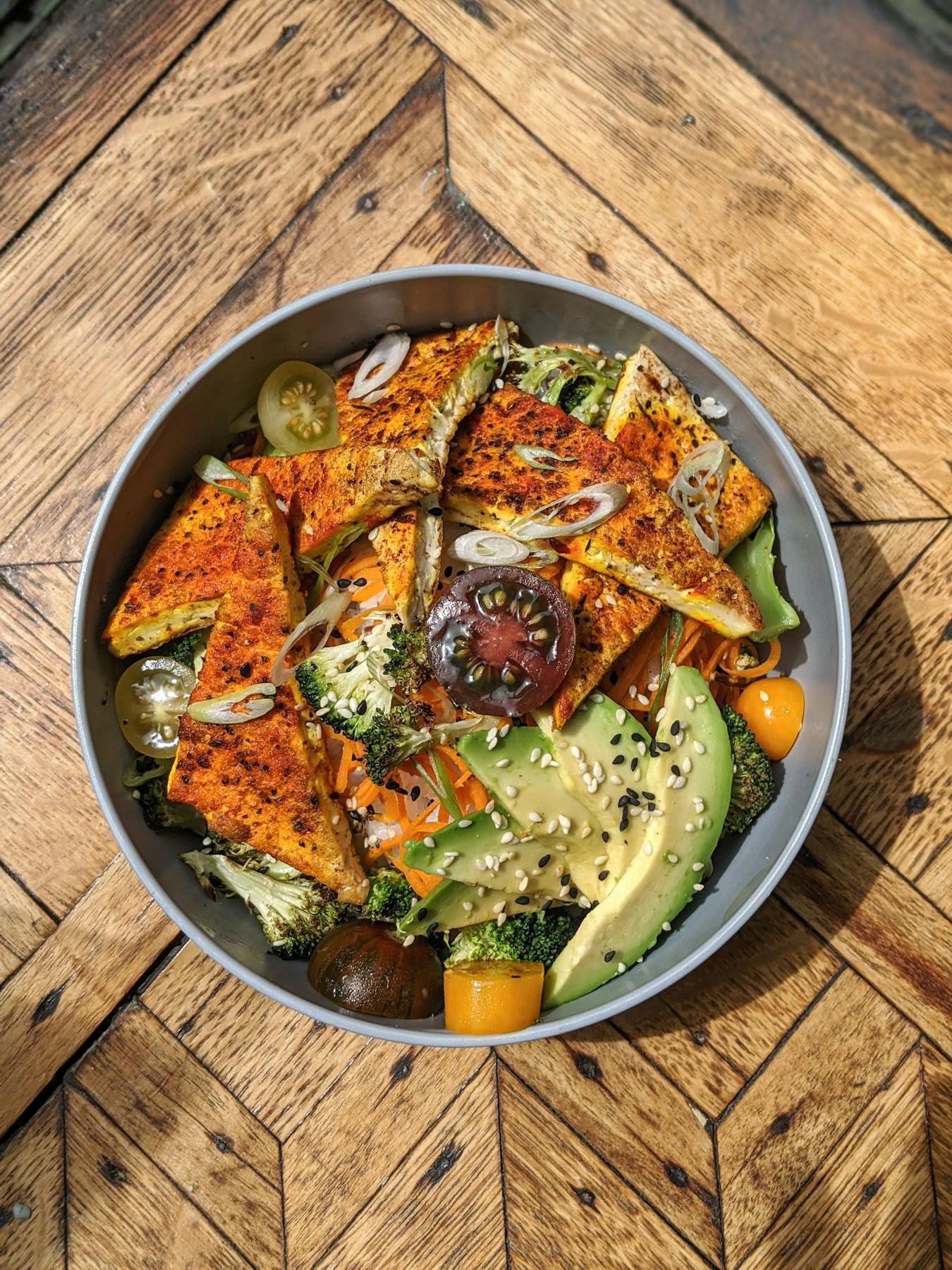 a bowl of food sitting on top of a wooden table
