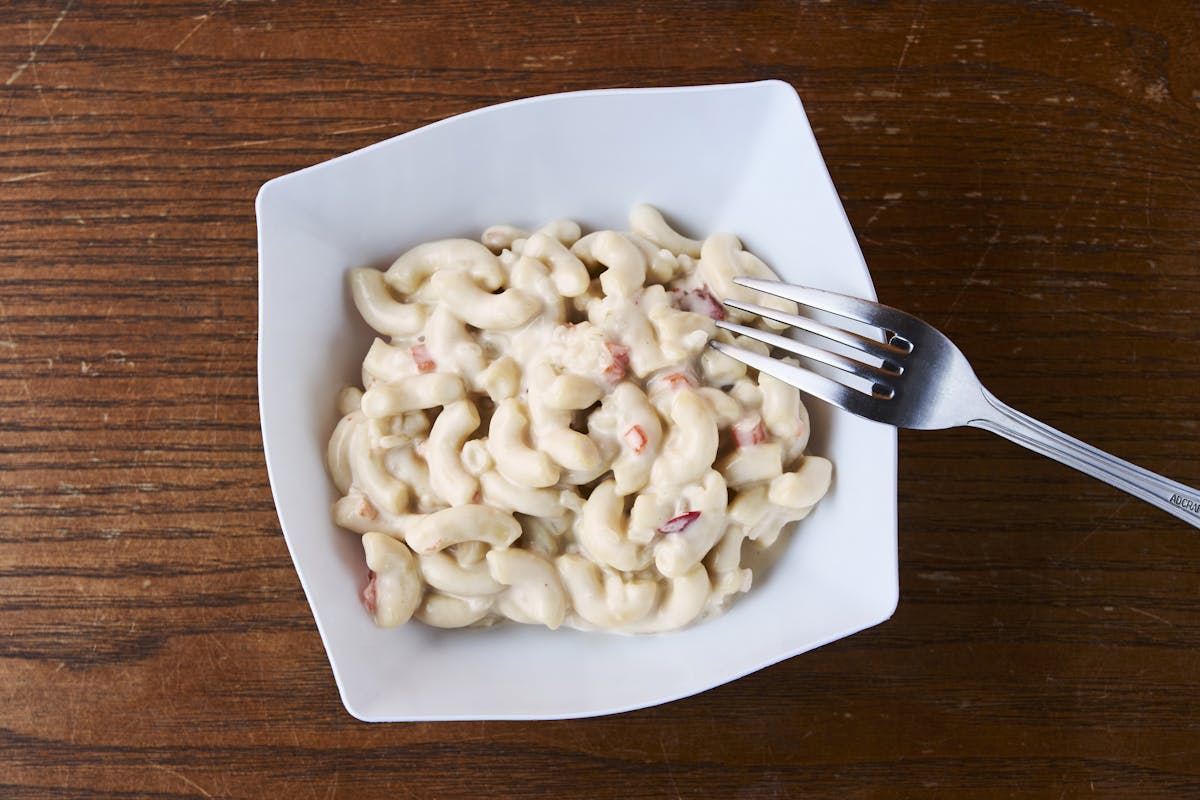 a spoon above a wooden table topped with a plate of food
