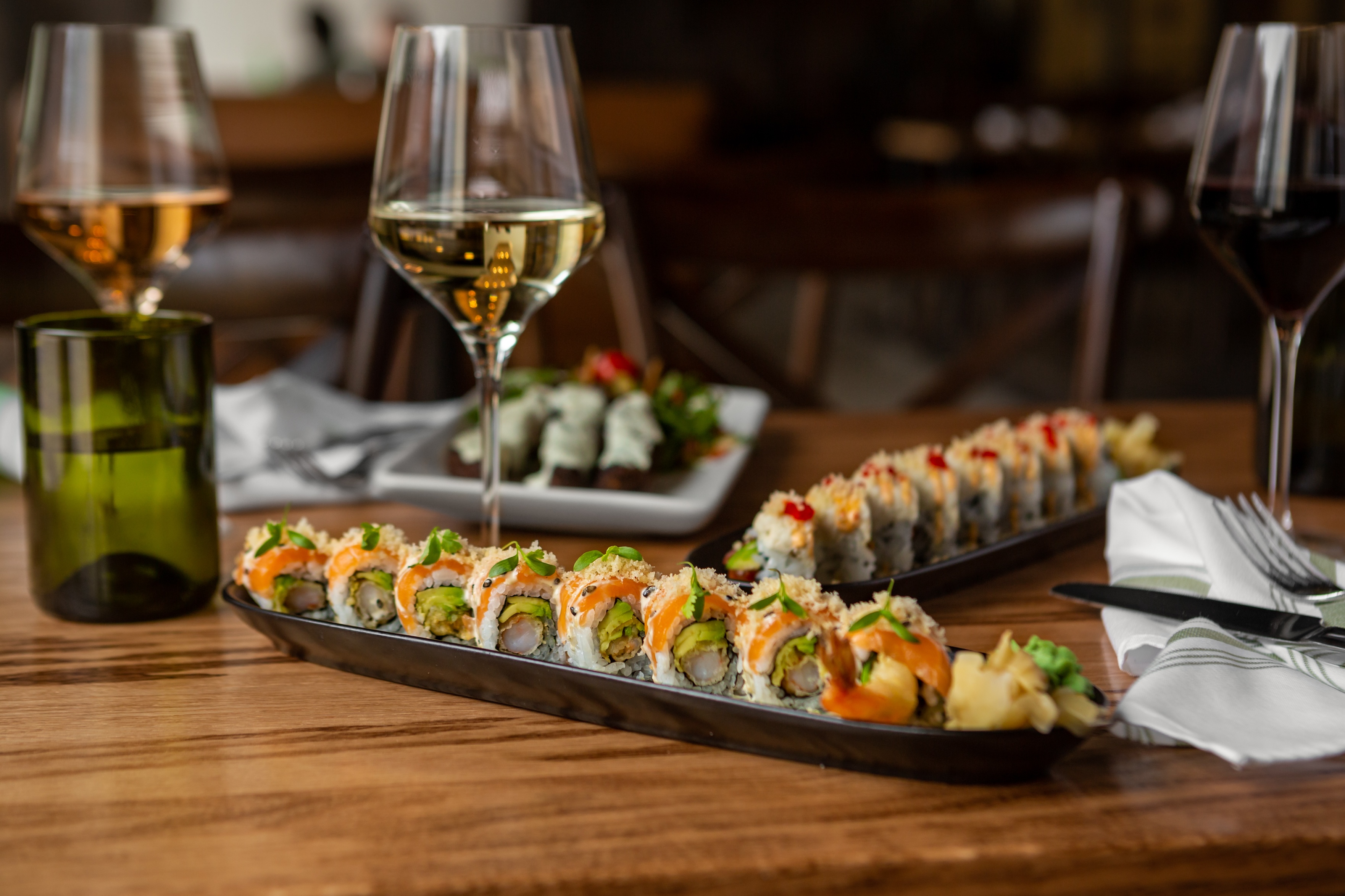 sushi on a table with wine glasses