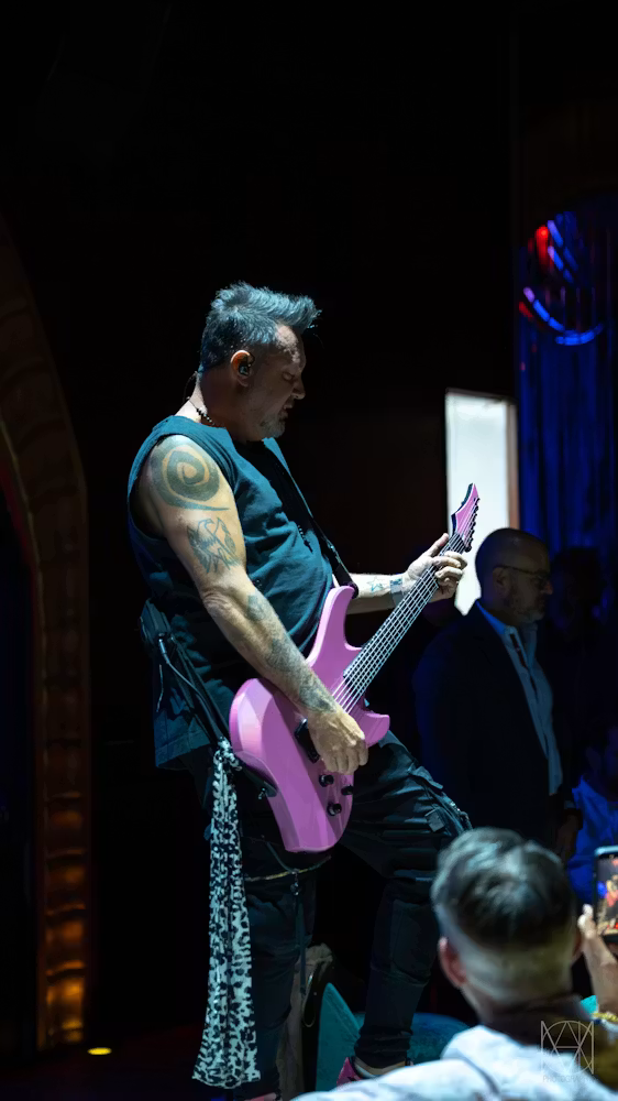 Ben Carey playing neon pink electric guitar at Las Vegas live music venue Caspian's Rock & Roe inside Caesars Palace