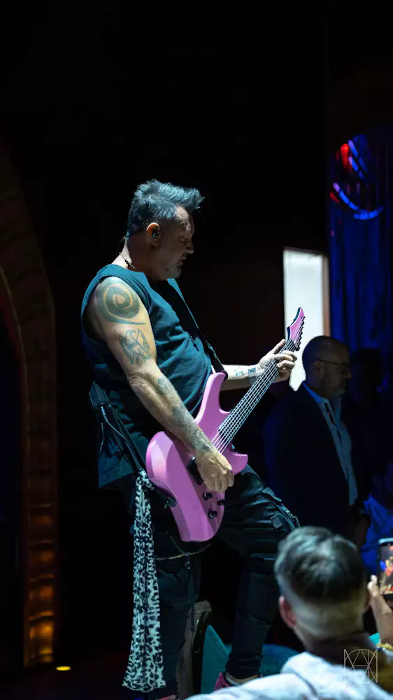 Ben Carey playing neon pink electric guitar at Las Vegas live music venue Caspian's Rock & Roe inside Caesars Palace