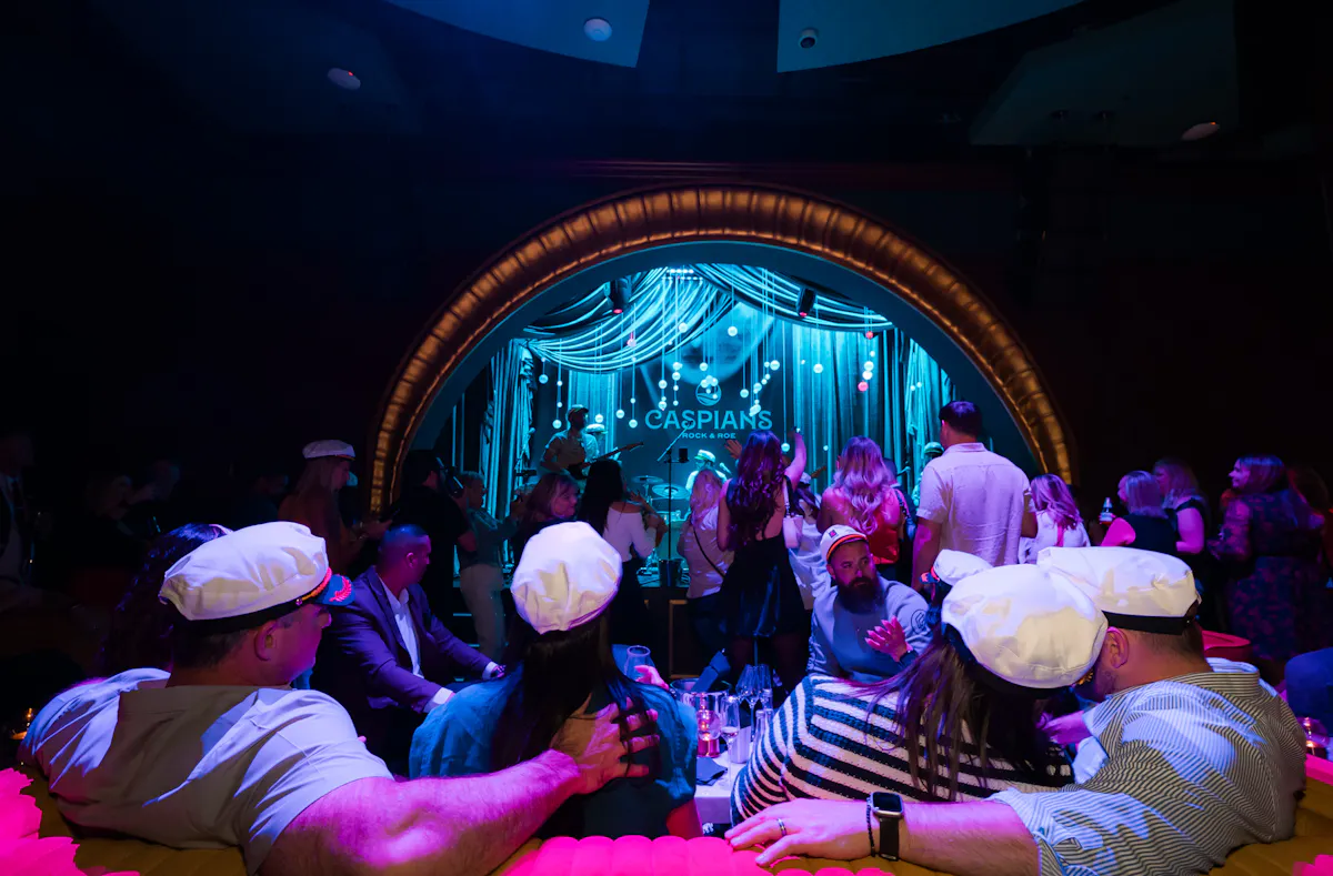 a group of people in a room with a stage and lights
