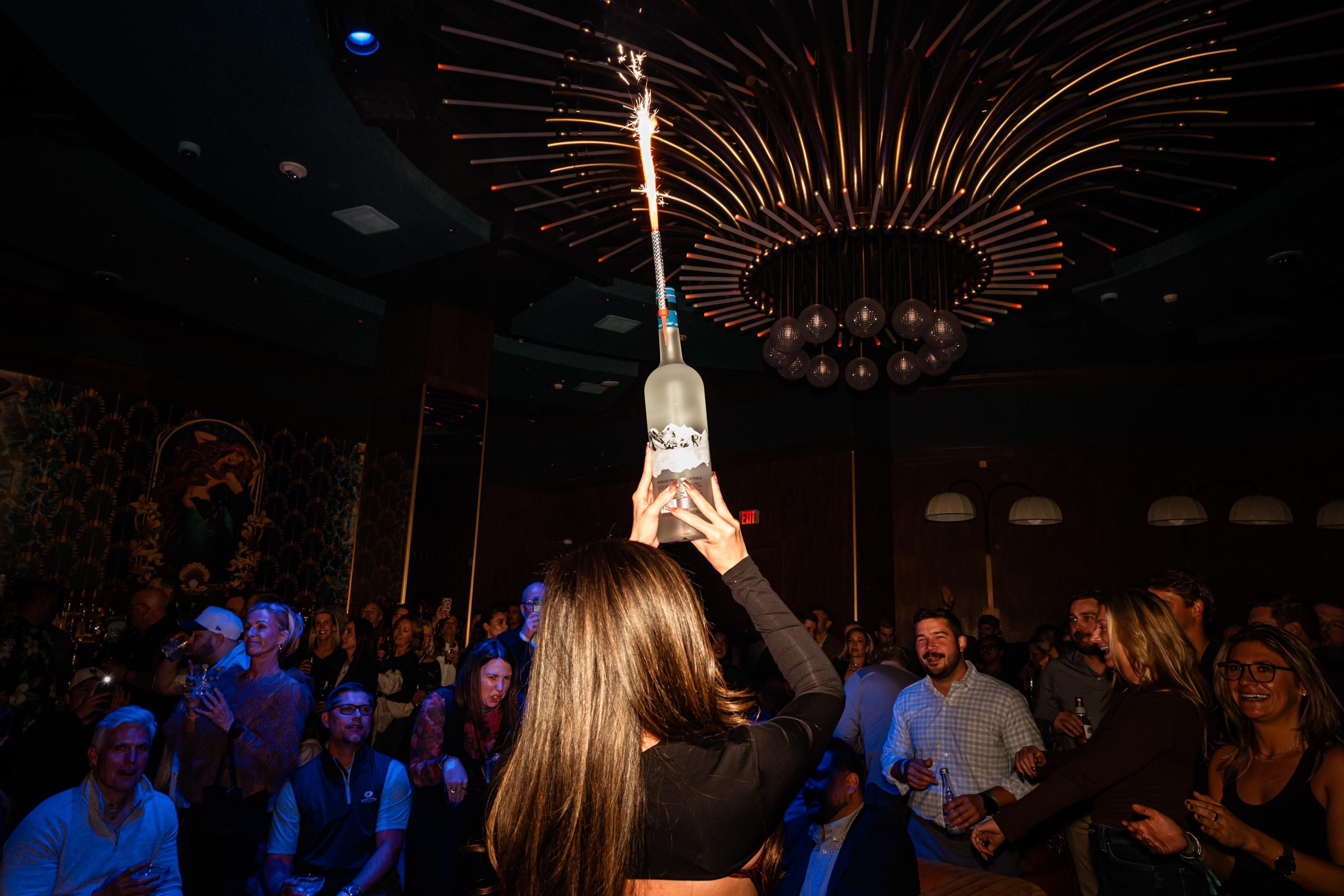 Bottle service girl holding bottle of vodka with sparkler at Las Vegas live music venue caspians