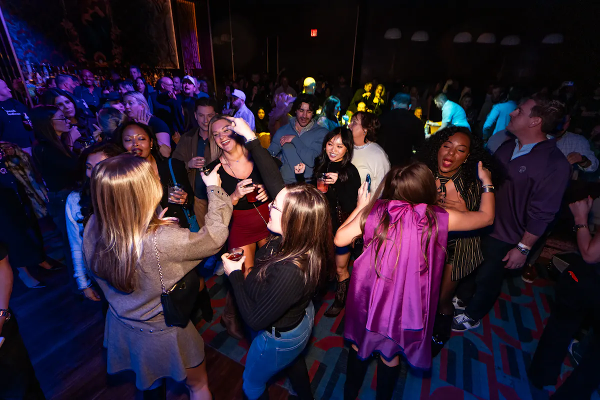 a group of people dancing in a dark room