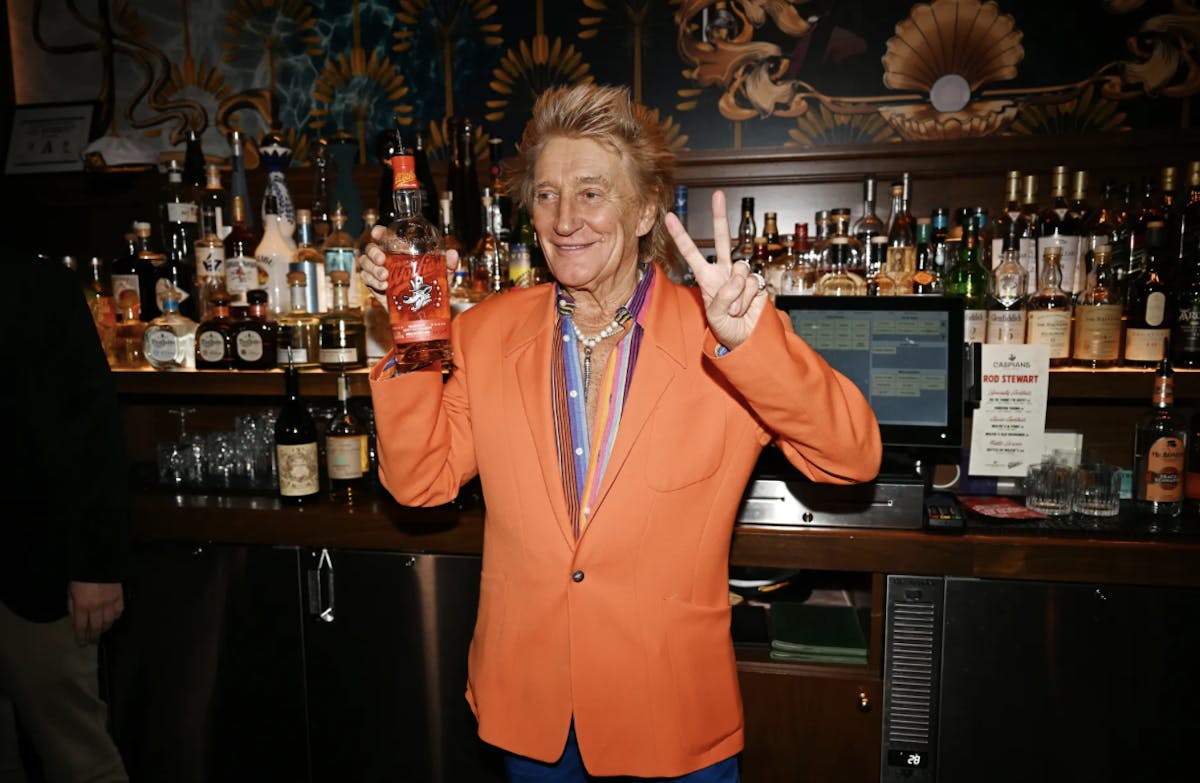 Rod Stewart standing in front of a restaurant