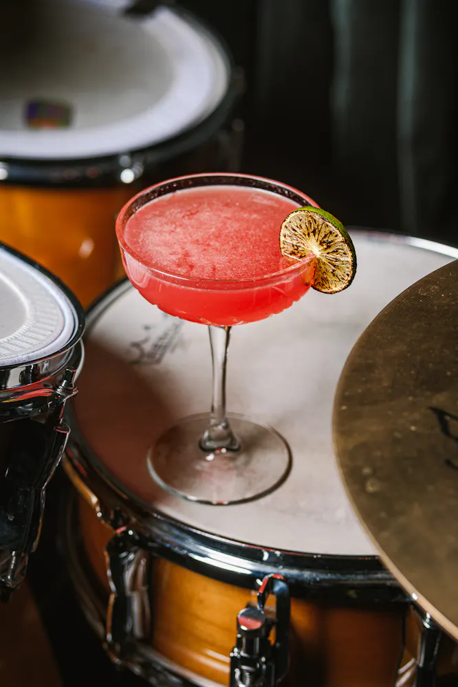 Cocktail in a martini glass sitting on top of drums at Las Vegas live music venue Caspian's Rock & Roe