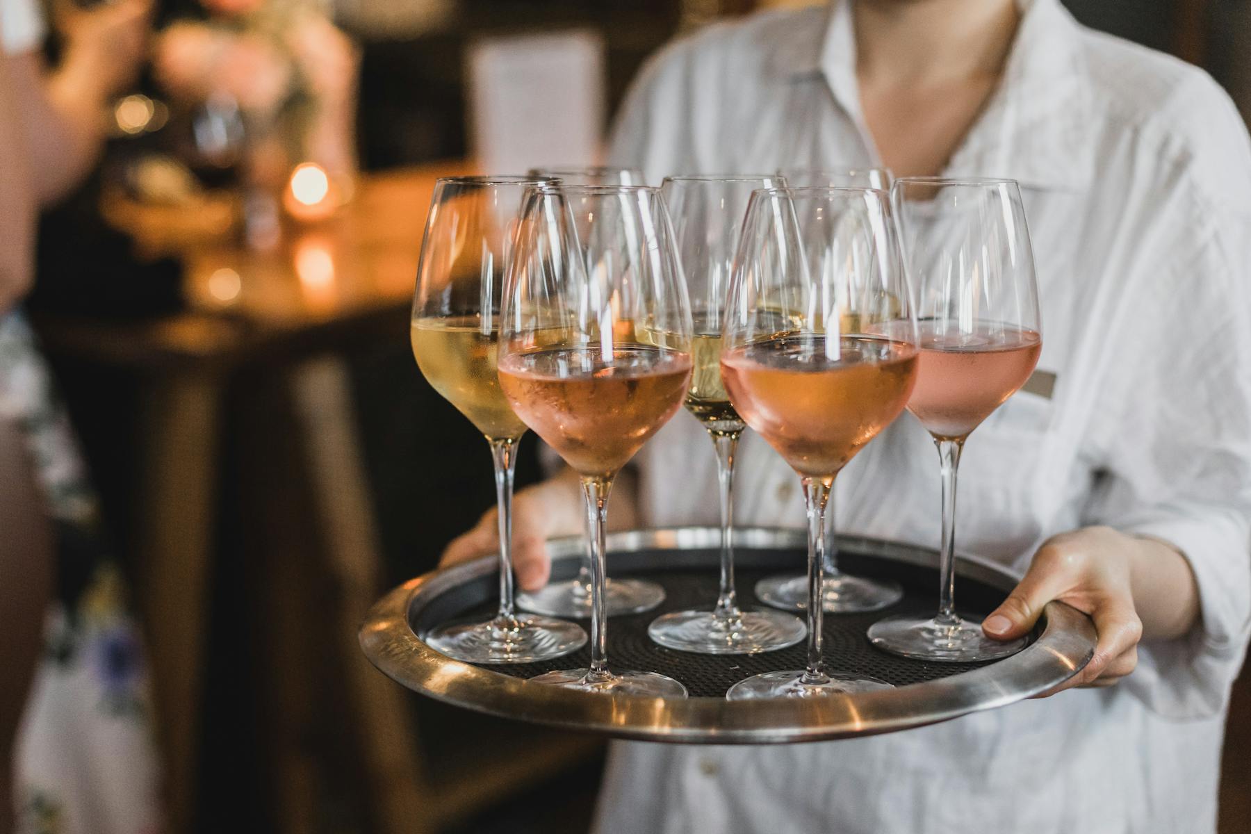 a person sitting at a table with wine glasses