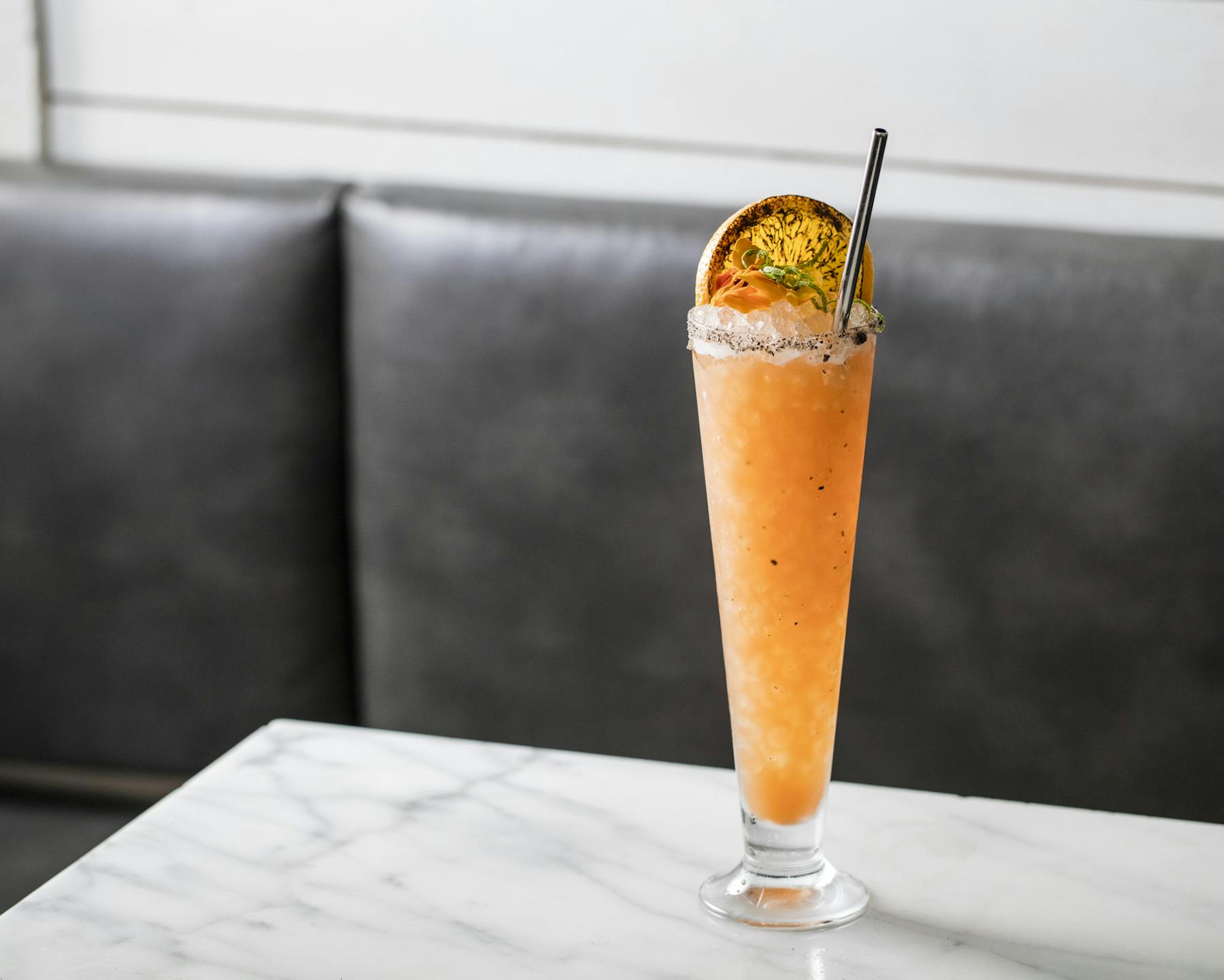 a glass with a orange colored drink