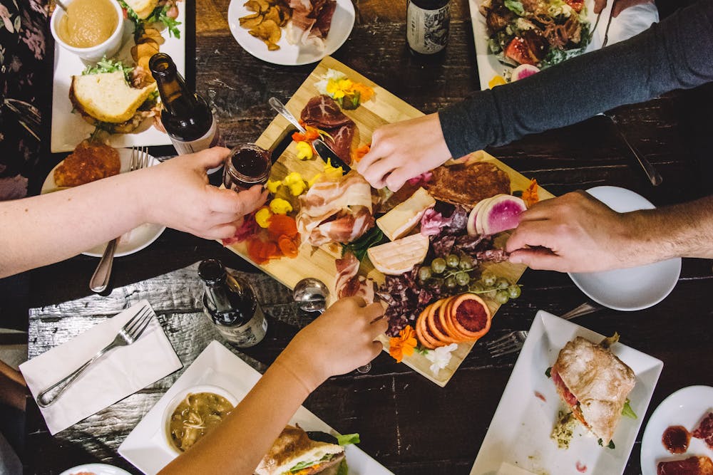 un groupe de personnes assises à une table avec une assiette de nourriture