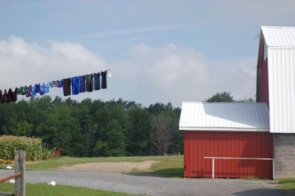 a laundry line adjacent to the exterior of a red barn