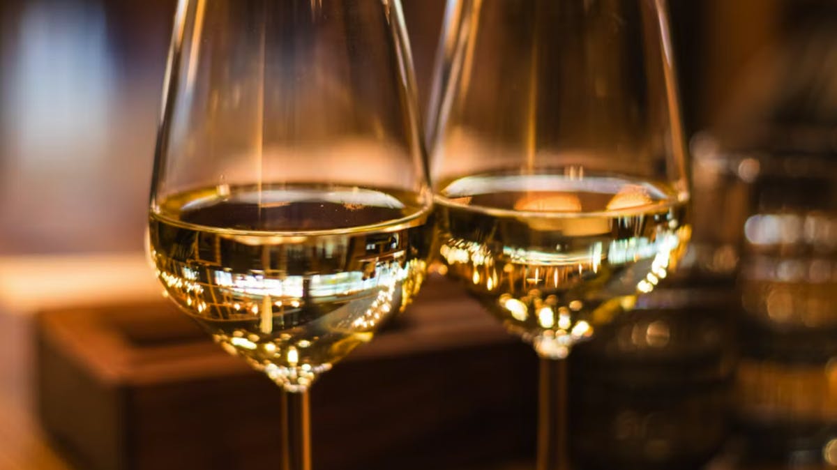 a glass of wine sitting on top of a wooden table