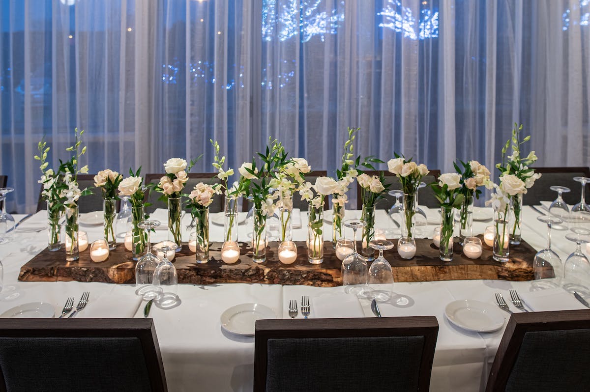 a vase of flowers on a table in front of a window