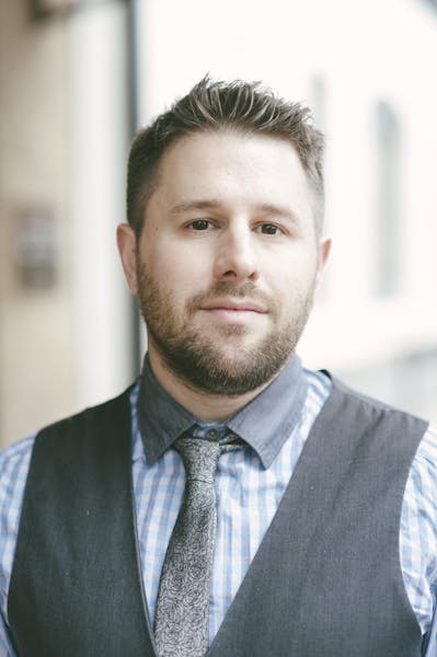a man wearing a suit and tie looking at the camera