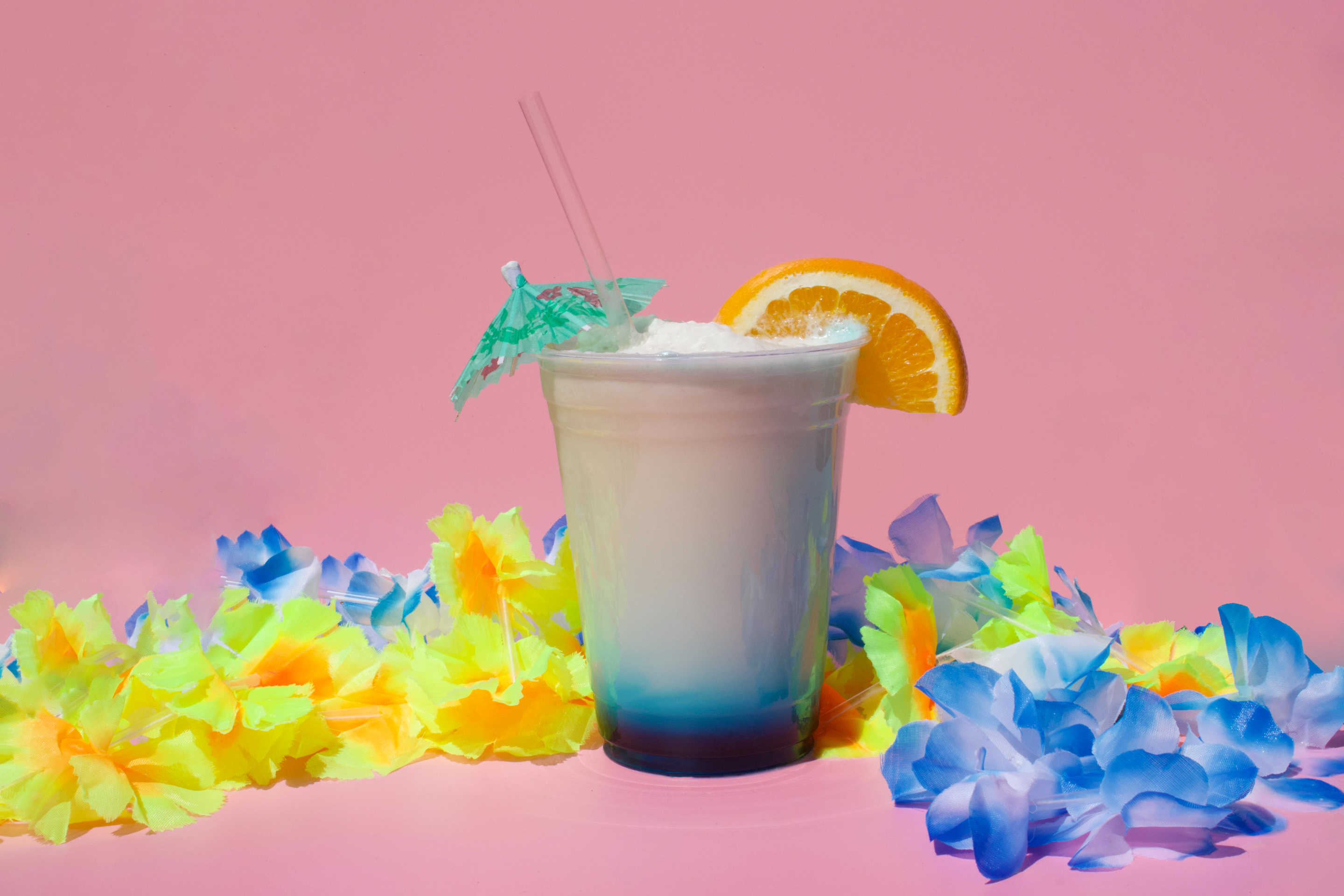 a drink with a straw and an umbrella on top of a flower