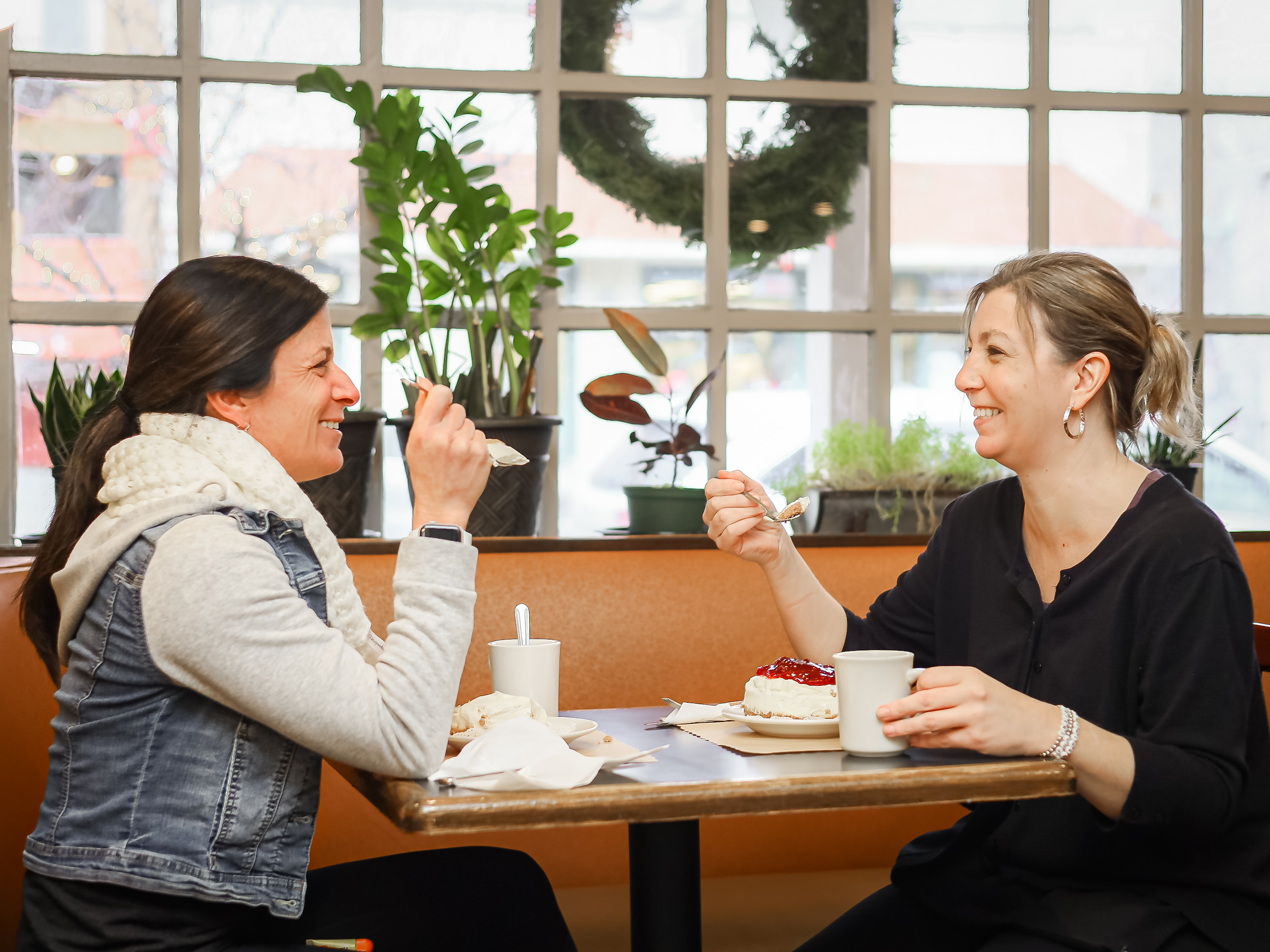 two people enjoying their food in a booth