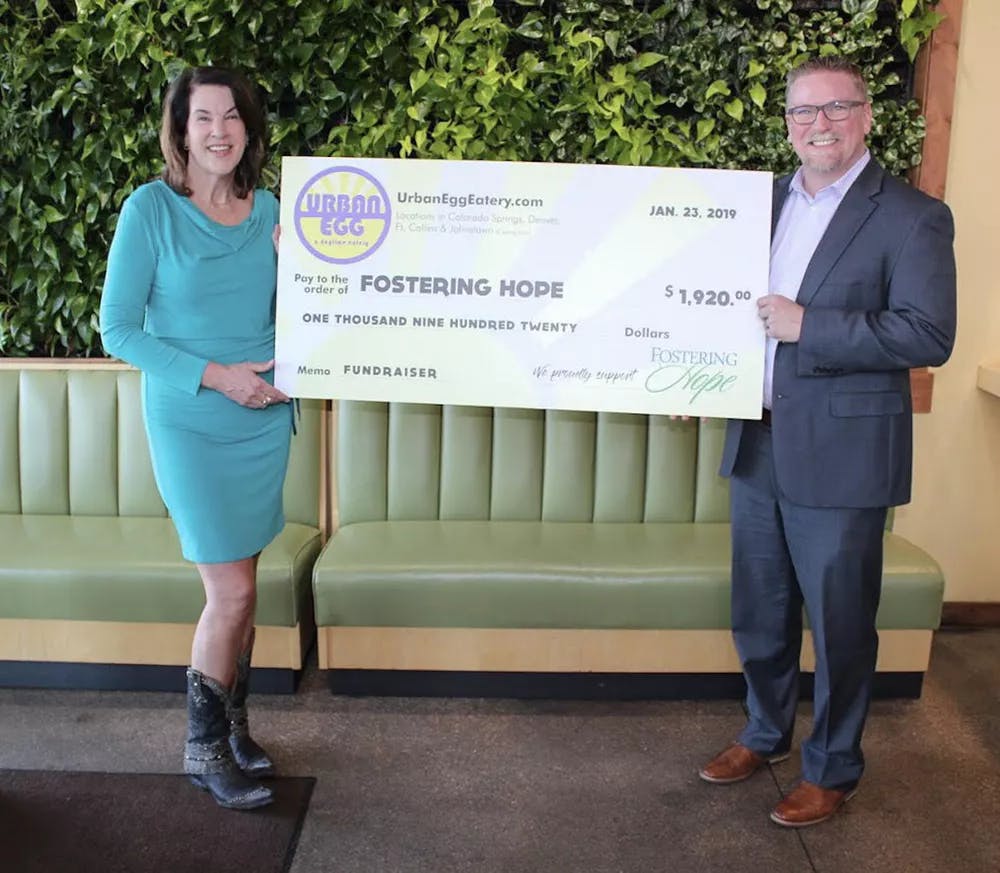 2 People Holding a Jumbo Check for Donation Presentation for Fostering Hope