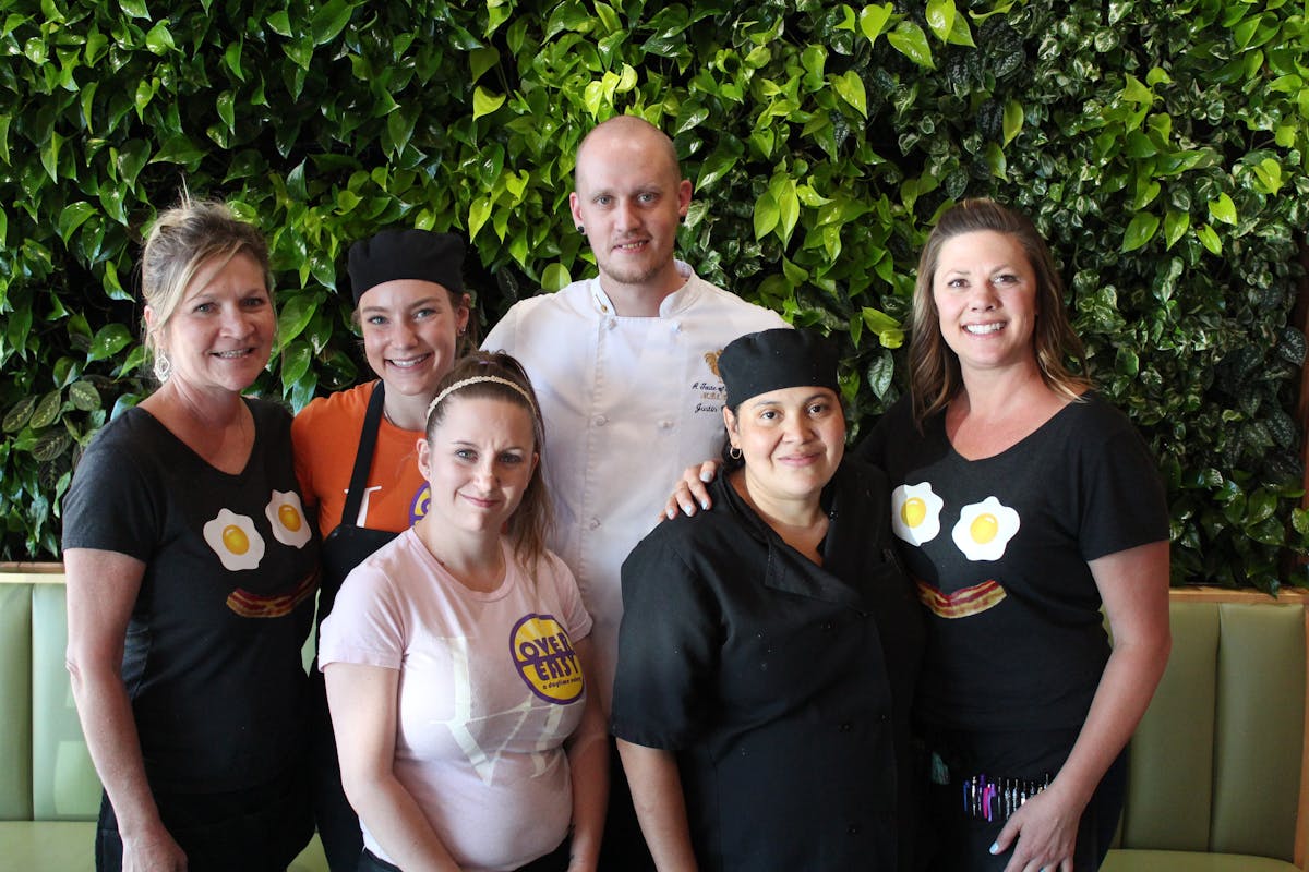 Group of Staff Members in Front of Green Wall