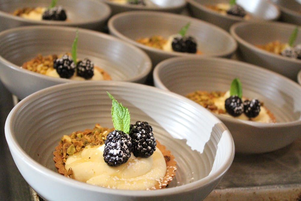 Catering Desserts in Bowls Topped with Blackberries and Mint