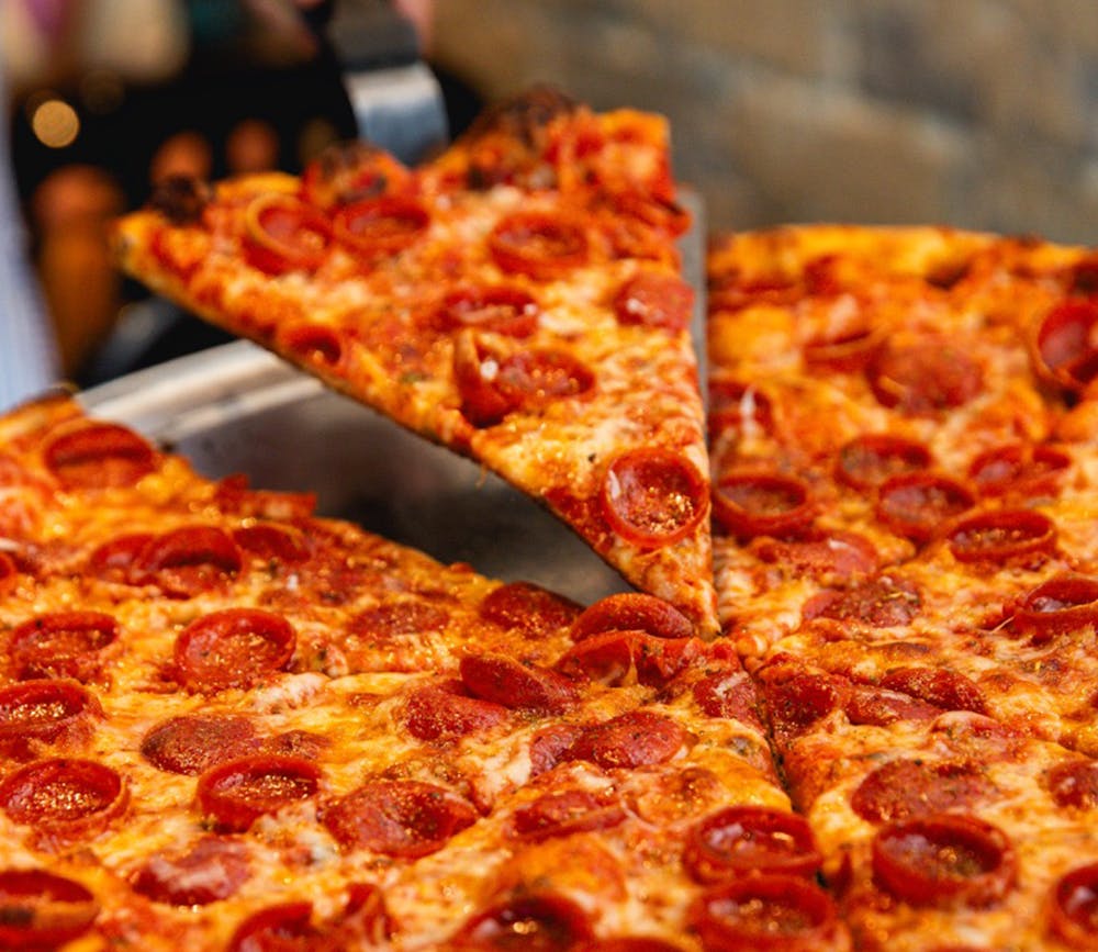 a pizza sitting on top of a wooden cutting board