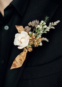 a person in a suit holding a flower