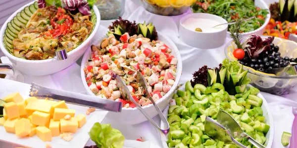 a bowl of salad on a picnic table