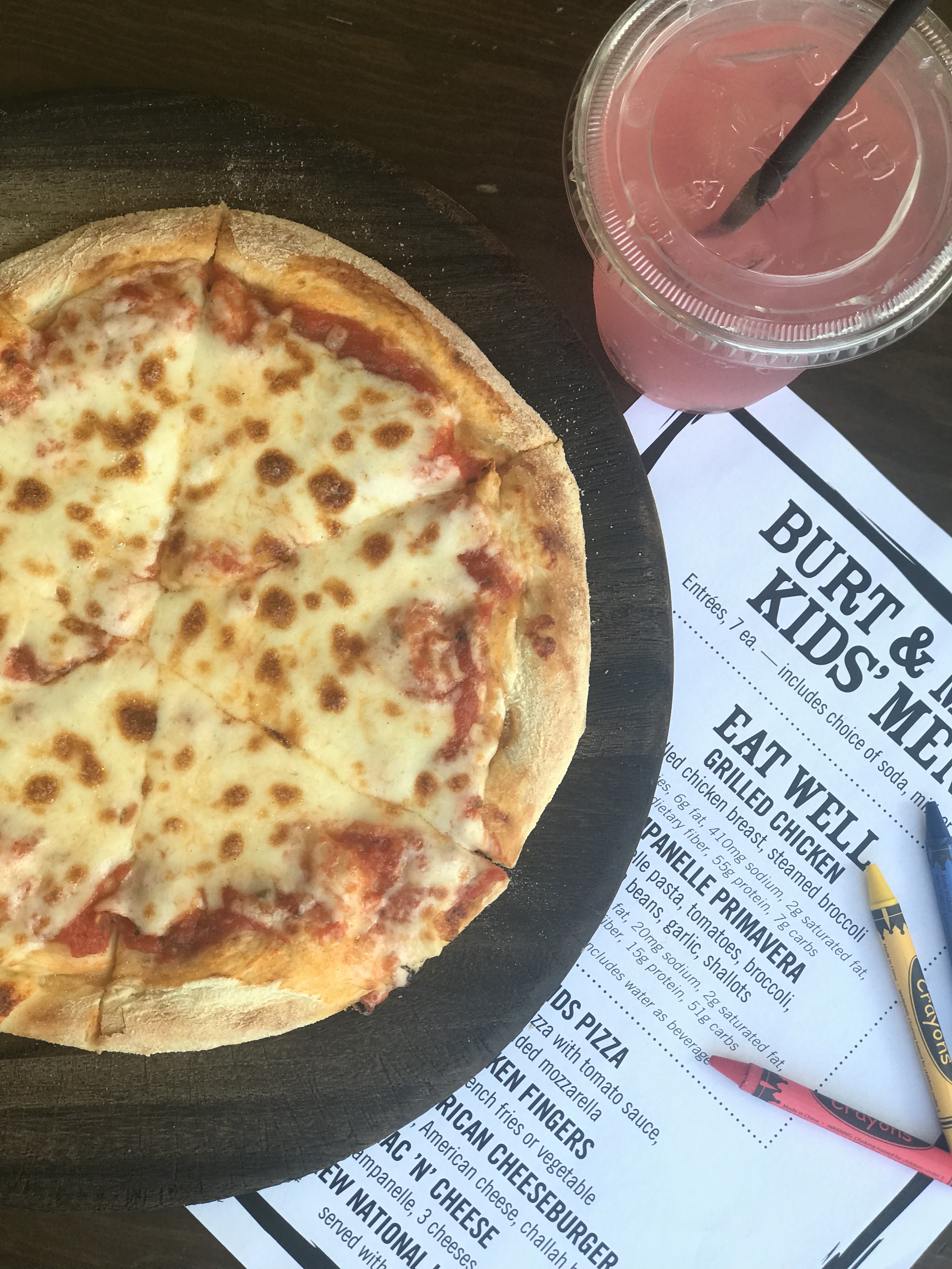 a pizza on a plate next to a drink