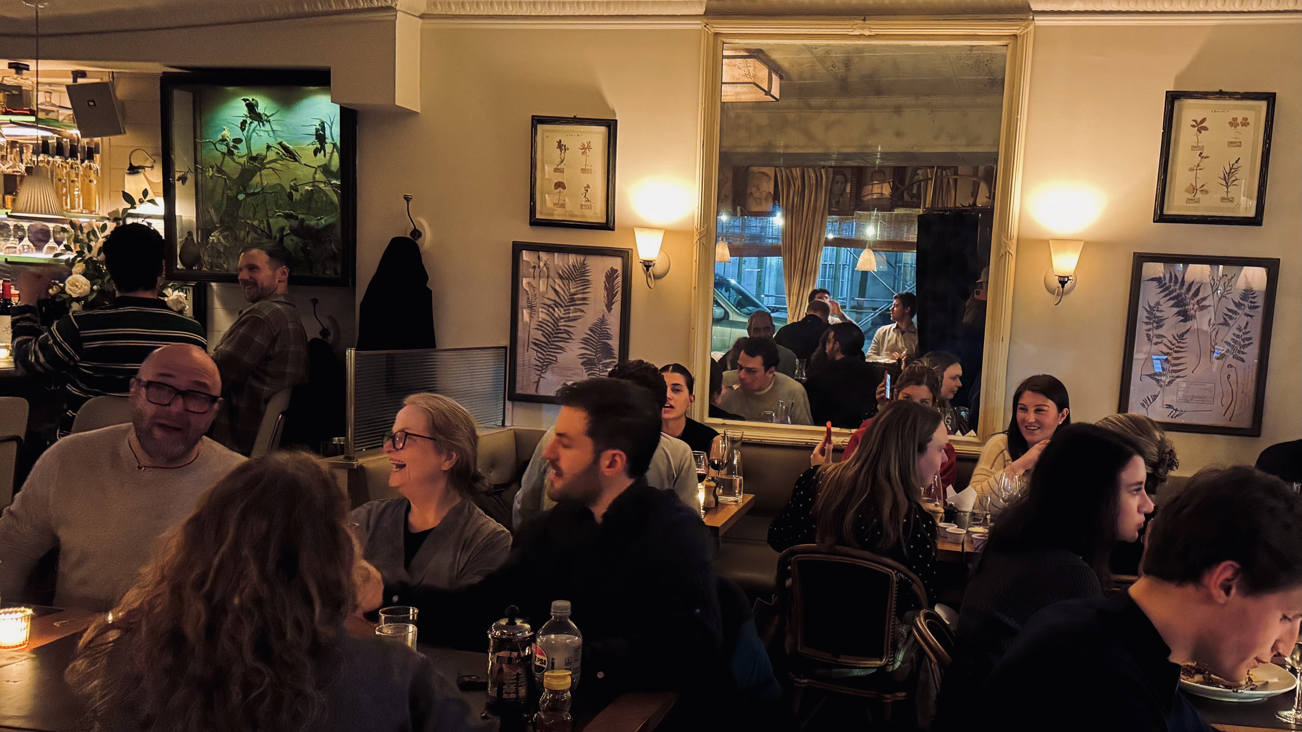 vibrant scene of diners and bar patrons enjoying the fun and lively ambiance at dinner with cocktails and glasses of wine, jovial and convivial atmosphere