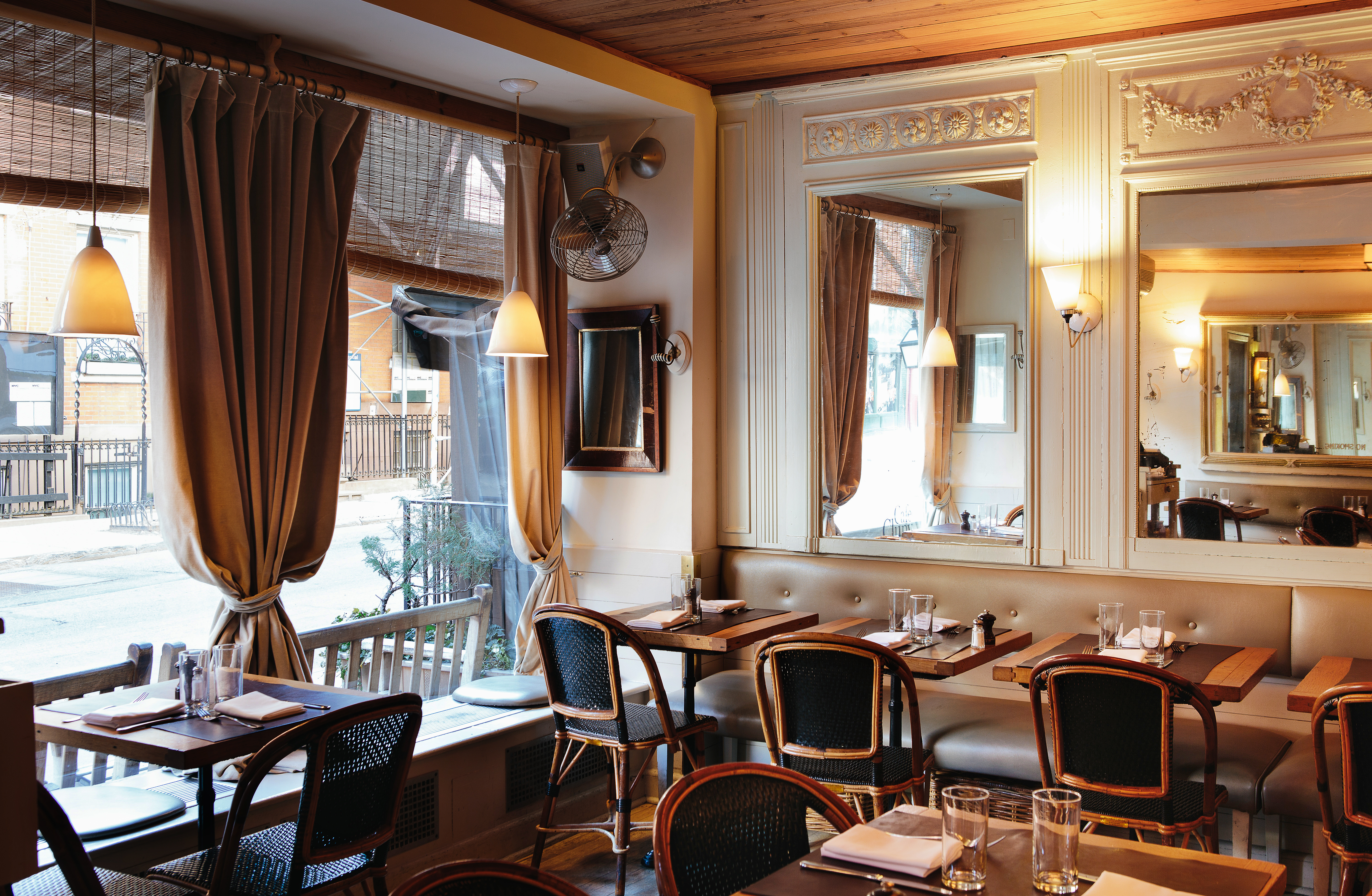 interior of back room with French cafe chairs and mirrors soft lighting velvet curtains muted colors