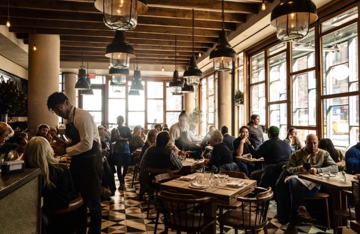 a group of people sitting at tables in a restaurant