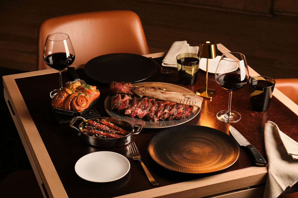 a table with plates of food and a glass of wine