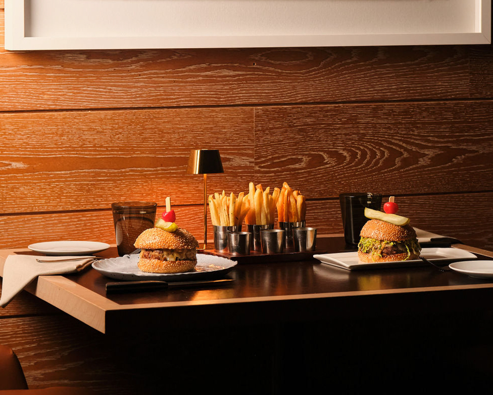 a table with burgers and fries