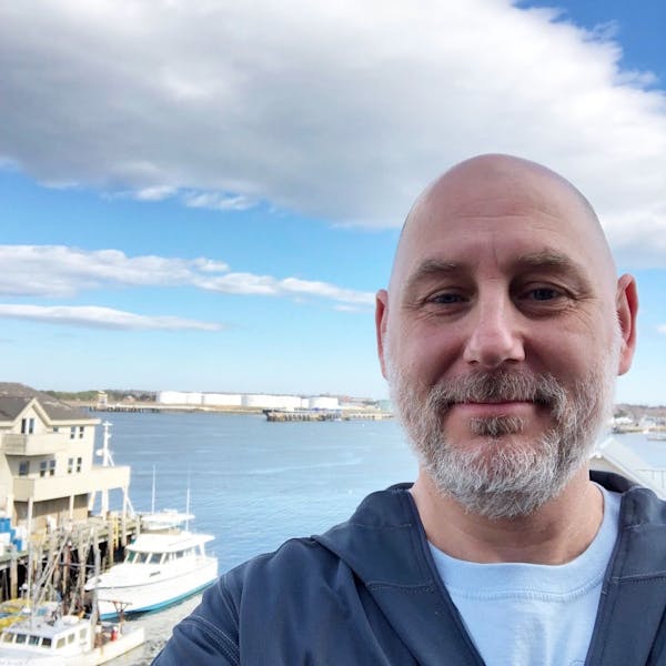 a man standing in front of a boat in the water
