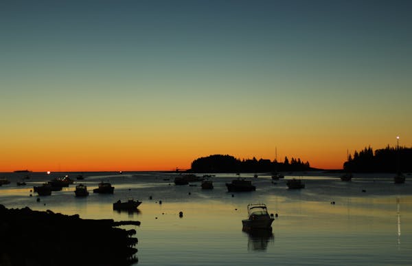 a sunset over a body of water with a city in the background