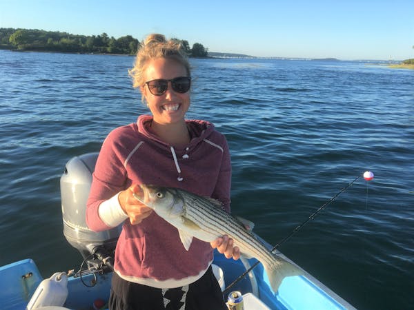 a person holding a fish on a boat in a body of water
