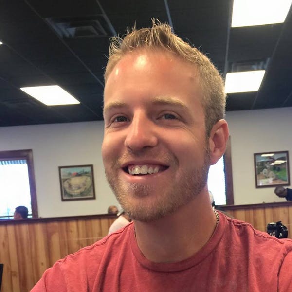 a man in a red shirt and smiling at the camera