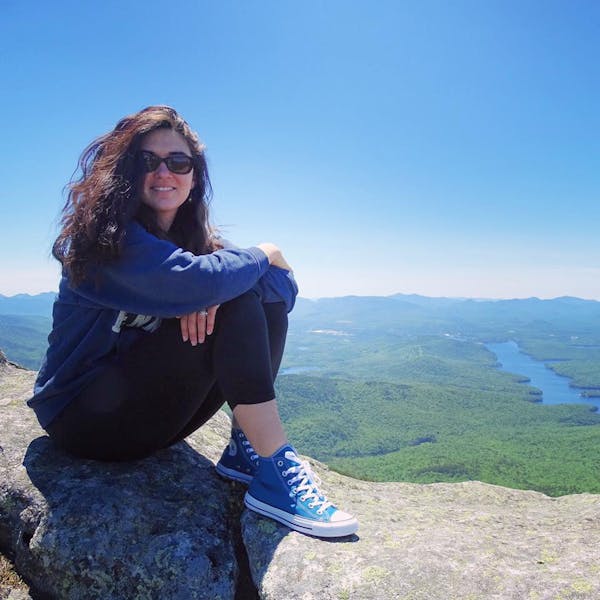 a woman standing in front of a mountain