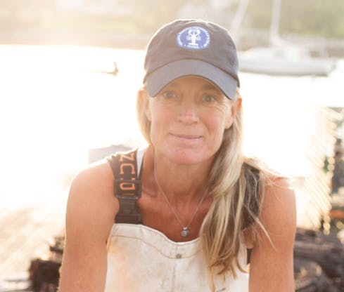 a woman wearing a hat and smiling at the camera