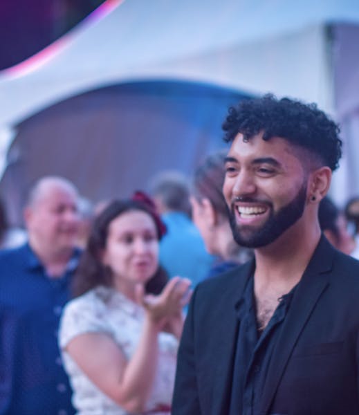 a man standing in front of a crowd posing for the camera
