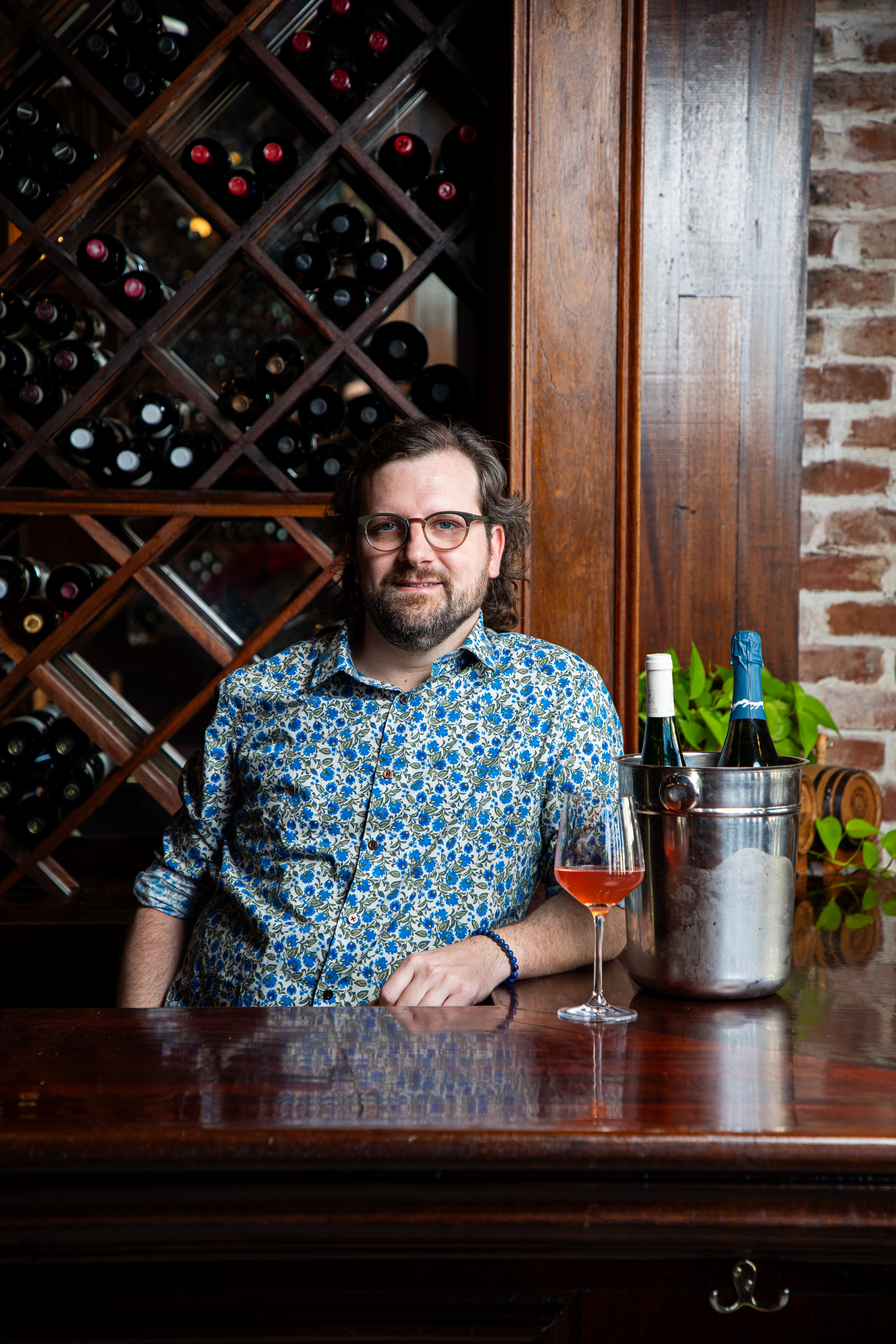 a man sitting at a table with wine glasses