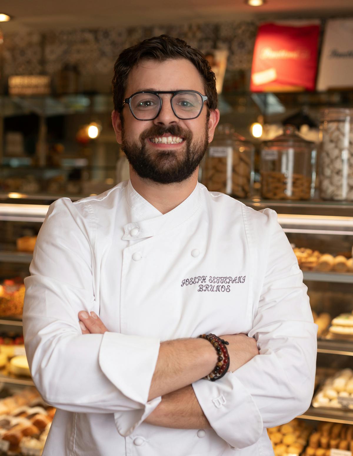 a man wearing glasses and smiling at the camera