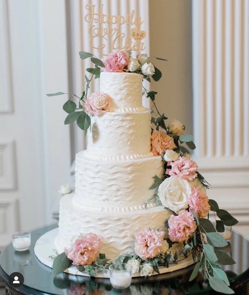 a vase of flowers sits in front of a wedding cake