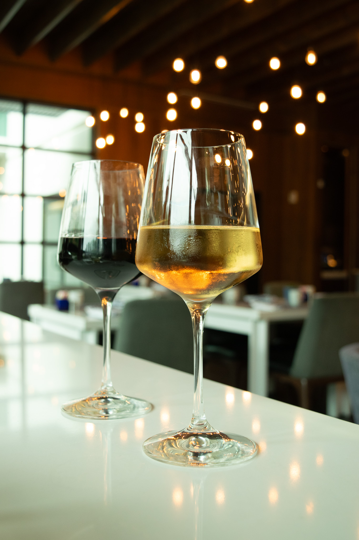 A glass of white wine and a glass of red wine on a white countertop at Portico Atlanta